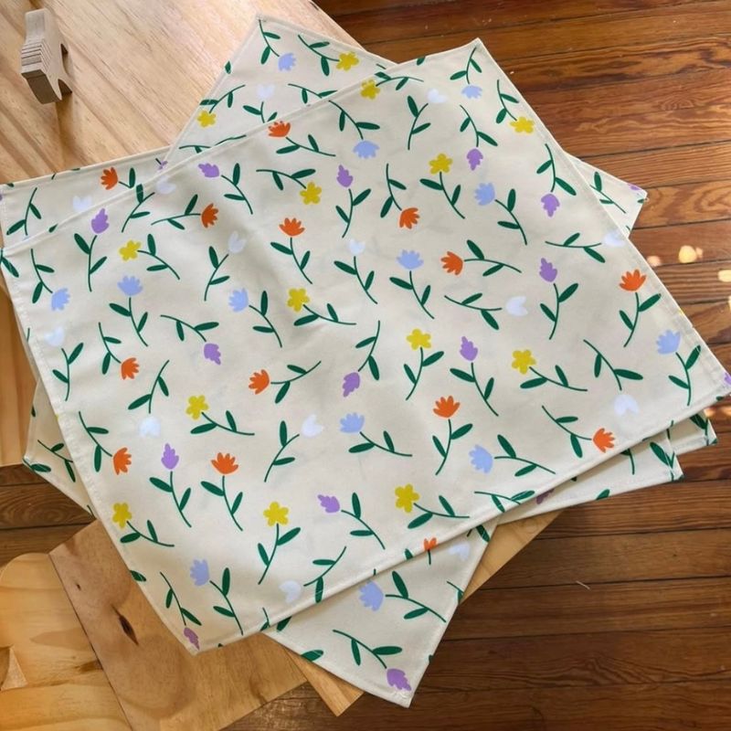 Colorful floral pattern placemats with orange, purple, and yellow flowers, charming home textile design by Mirador Art Studio.