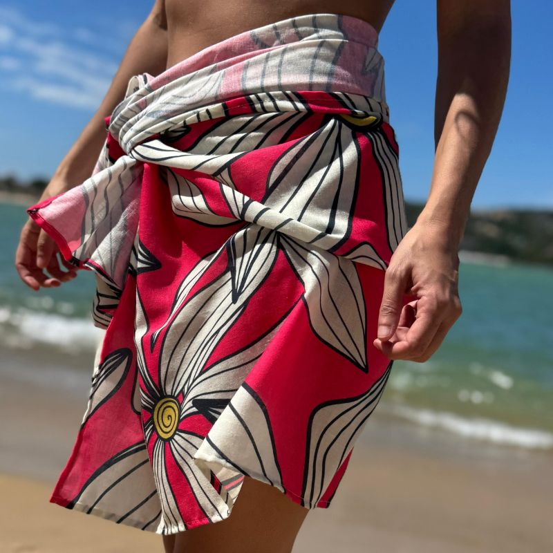 Sarong with bold floral pattern at the beach, textile design and art licensing example by Mirador Art Studio.