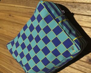 Neceser grande de tela impermeable y diseño de cuadros azules y celeste con amarillo.