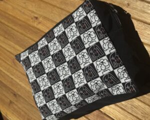 Neceser grande con diseño cuadros blanco y negro con retratos mujeres tipo cartoon. Tela impermeable.